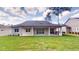 Backyard featuring a covered patio, outdoor kitchen, and a lush green lawn at 4507 Majestic Hill Loop, Brooksville, FL 34601