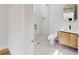 Modern bathroom with a sleek glass shower, floating wood vanity, and round mirror at 4507 Majestic Hill Loop, Brooksville, FL 34601