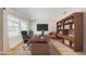 Bright home office featuring a large desk, custom bookshelves, and large window view at 4507 Majestic Hill Loop, Brooksville, FL 34601