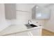 Modern laundry room featuring sleek cabinetry, quartz countertops, and stainless steel sink at 4507 Majestic Hill Loop, Brooksville, FL 34601
