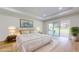 Staged main bedroom with tray ceiling, sliding glass doors, and designer furnishings at 4507 Majestic Hill Loop, Brooksville, FL 34601