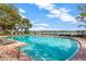 Community pool with clear blue water, surrounded by lounge chairs and a view of the lake at 4655 Pond Ridge Dr, Riverview, FL 33578