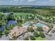 Aerial view of community pool, clubhouse, lake, and green space, promising an active lifestyle at 4831 Royal Birkdale Way, Wesley Chapel, FL 33543