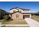 Charming two-story home with a stone facade, a well-manicured lawn, and a two-car garage at 4831 Royal Birkdale Way, Wesley Chapel, FL 33543