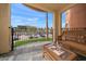 Relaxing balcony featuring a wicker couch with scenic views of nearby building and palm trees at 5301 Gulf Blvd # C202, St Pete Beach, FL 33706
