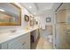 Bright bathroom with double sinks, tile floors, and a glass-enclosed shower at 5301 Gulf Blvd # C202, St Pete Beach, FL 33706
