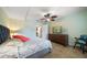 Bedroom with a large bed, dresser with TV, ceiling fan, and doorway to bathroom at 5301 Gulf Blvd # C202, St Pete Beach, FL 33706
