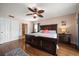 Cozy bedroom featuring a dark wood bed frame, ceiling fan, and bedside tables at 5301 Gulf Blvd # C202, St Pete Beach, FL 33706