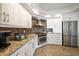 Well-equipped kitchen with stainless steel appliances, sleek white cabinetry and granite counters at 5301 Gulf Blvd # C202, St Pete Beach, FL 33706