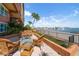 Waterfront condo patio with seating, offering serene bay views, and tropical landscaping at 5301 Gulf Blvd # C202, St Pete Beach, FL 33706