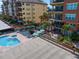 Community pool and outdoor seating area, surrounded by well-maintained landscaping and residential buildings at 5301 Gulf Blvd # C202, St Pete Beach, FL 33706
