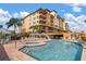 Community pool with lounge chairs, cabanas, and building in the background at 5301 Gulf Blvd # C202, St Pete Beach, FL 33706