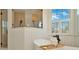Bright bathroom featuring a soaking tub and shower with black hardware and a window with plantation shutters at 536 Ontario Ave, Crystal Beach, FL 34681