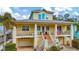 Charming yellow two-story home with a welcoming front porch, brick stairs, and well-manicured landscaping at 536 Ontario Ave, Crystal Beach, FL 34681