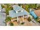 Beautiful, elevated coastal home with covered porches, lush landscaping, and brick paved driveway at 536 Ontario Ave, Crystal Beach, FL 34681