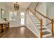 Welcoming foyer featuring hardwood floors, an elegant chandelier, and a staircase with white railings at 536 Ontario Ave, Crystal Beach, FL 34681