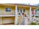 Welcoming front entrance with brick stairs, white railings, and a covered porch on a charming two-story home at 536 Ontario Ave, Crystal Beach, FL 34681