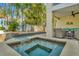 Relaxing backyard hot tub and pool area with waterfall feature and comfortable seating under a covered patio at 536 Ontario Ave, Crystal Beach, FL 34681