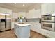 Modern kitchen with white cabinets, stainless steel appliances, an island, and hardwood floors at 536 Ontario Ave, Crystal Beach, FL 34681
