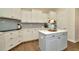 Stylish kitchen featuring a gray island, white cabinets, and stainless steel appliances at 536 Ontario Ave, Crystal Beach, FL 34681