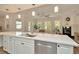 Open-concept area featuring a white kitchen with a stainless steel dishwasher, a fireplace, and a living room at 536 Ontario Ave, Crystal Beach, FL 34681