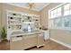 Bright home office with custom built-ins, plantation shutters, a gold desk, and hardwood flooring at 536 Ontario Ave, Crystal Beach, FL 34681