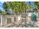 Built-in outdoor kitchen with stainless steel grill, perfect for outdoor cooking and entertaining in tropical landscaping at 536 Ontario Ave, Crystal Beach, FL 34681