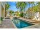Beautiful pool with tile surround, waterfalls, and lush tropical landscaping at 536 Ontario Ave, Crystal Beach, FL 34681