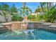 Beautiful pool with a waterfall and basketball hoop creates a fun and inviting backyard space at 536 Ontario Ave, Crystal Beach, FL 34681