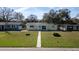 Inviting front view of the house surrounded by a lush green lawn and mature trees at 636 41St Ne Ave, St Petersburg, FL 33703