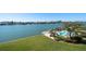 Beautiful waterfront property featuring a pool, dock, boat, and manicured lawn at 700 Island Way # 404, Clearwater Beach, FL 33767