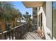 Cozy balcony with a small table overlooking palm trees and nearby buildings at 74 Gulf Blvd # 2B, Indian Rocks Beach, FL 33785