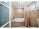 Cozy bathroom with tiled walls, a bathtub with shower curtain, and a window with blinds at 74 Gulf Blvd # 2B, Indian Rocks Beach, FL 33785