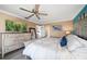 Comfortable bedroom featuring a dresser with a tv, a ceiling fan, and light colored walls and trim at 74 Gulf Blvd # 2B, Indian Rocks Beach, FL 33785