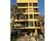 A multi-story condo building with private balconies and covered parking, landscaped with palm trees at 74 Gulf Blvd # 2B, Indian Rocks Beach, FL 33785
