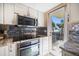 Modern kitchen features stainless steel appliances, granite countertops, and glass tile backsplash, with balcony access at 74 Gulf Blvd # 2B, Indian Rocks Beach, FL 33785