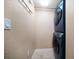 Small laundry room features a stacked washer and dryer set, with tile flooring and wall mounted storage at 74 Gulf Blvd # 2B, Indian Rocks Beach, FL 33785