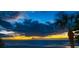 A peaceful sunset view of the ocean shows a colorful horizon with scattered clouds and a silhouetted palm tree at 74 Gulf Blvd # 2B, Indian Rocks Beach, FL 33785