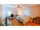 Well-lit bedroom offers hardwood floors, ceiling fan, closet, study space, and a king-sized bed at 8350 Savannah Trace Cir # 1808, Tampa, FL 33615