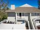 Two-story condo featuring a brown roof, white siding, a balcony, a ground-floor patio, stairs, and an outdoor grilling area at 8350 Savannah Trace Cir # 1808, Tampa, FL 33615