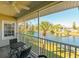Relaxing screened-in porch with seating and serene water views of the lake and a palm tree at 8350 Savannah Trace Cir # 1808, Tampa, FL 33615