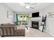 Comfortable living room has a fireplace, mounted TV, plants, and slider to outdoor lanai at 9100 Dr Martin Luther King Jr N St # 1508, St Petersburg, FL 33702