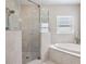 Bathroom featuring glass shower, garden tub, and stylish fixtures at 102 Adriatic Ave, Tampa, FL 33606