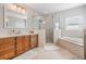 The bright main bathroom offers a glass shower, soaking tub, and vanity with storage at 102 Adriatic Ave, Tampa, FL 33606