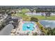 An aerial view of the community pool, golf course, and lake provides a serene environment for an active lifestyle at 10237 Collar Dr, San Antonio, FL 33576