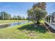 Spacious backyard featuring lush green grass, mature trees, and a tranquil water view at 10237 Collar Dr, San Antonio, FL 33576