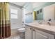 Bathroom with a single sink vanity, shower-tub combo, and light blue walls at 10237 Collar Dr, San Antonio, FL 33576