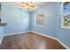 Open concept kitchen nook area featuring wood floors, soft blue paint, and natural light from the windows at 10237 Collar Dr, San Antonio, FL 33576