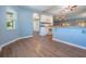 Open concept kitchen nook area featuring wood floors, soft blue paint, and natural light from the windows at 10237 Collar Dr, San Antonio, FL 33576