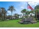 Tampa Bay Golf and Country Club entrance sign surrounded by lush landscaping and palm trees waving against a blue sky at 10237 Collar Dr, San Antonio, FL 33576